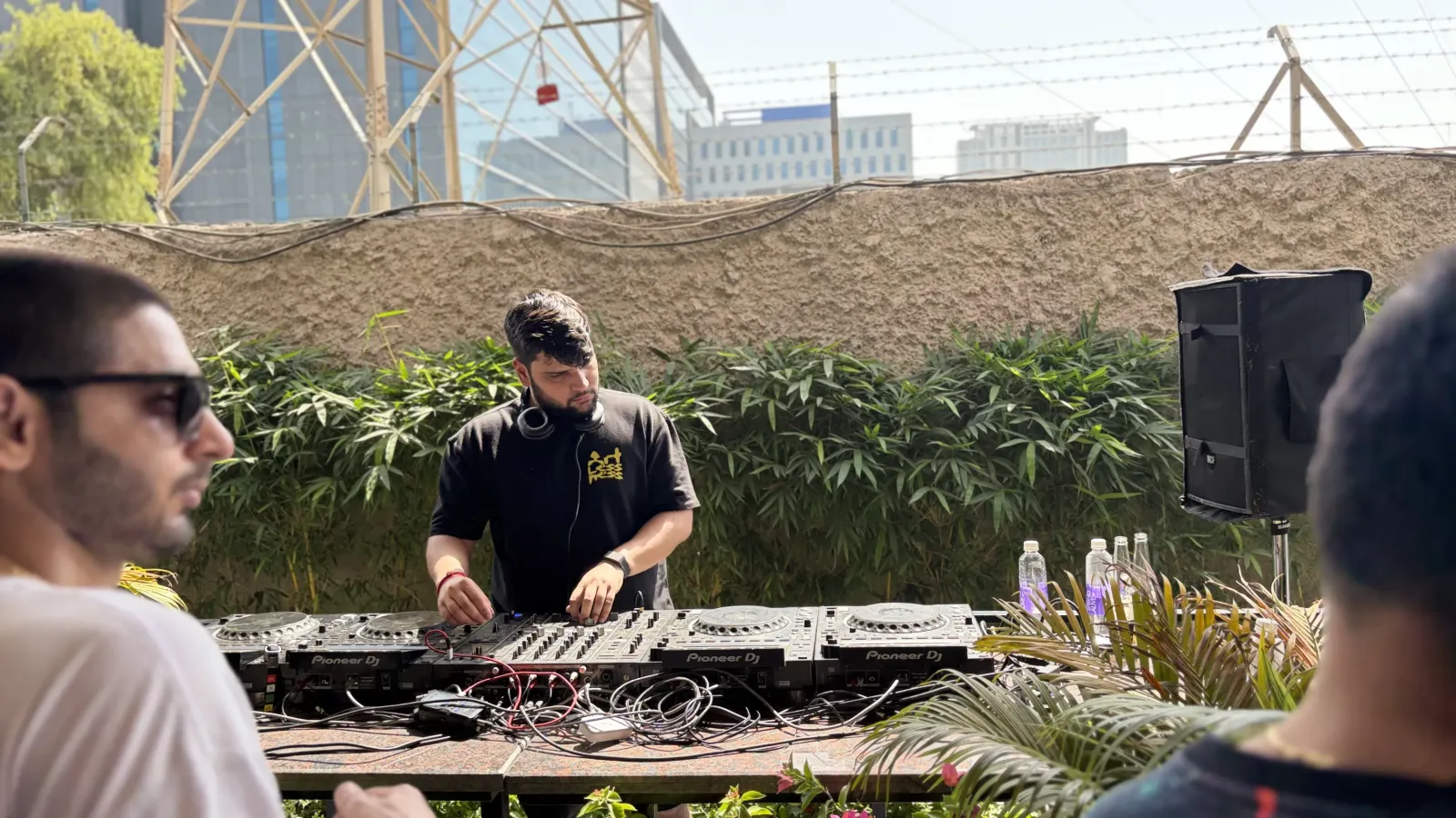 BITFLIP on the decks at a daytime open-air set, city skyline behind